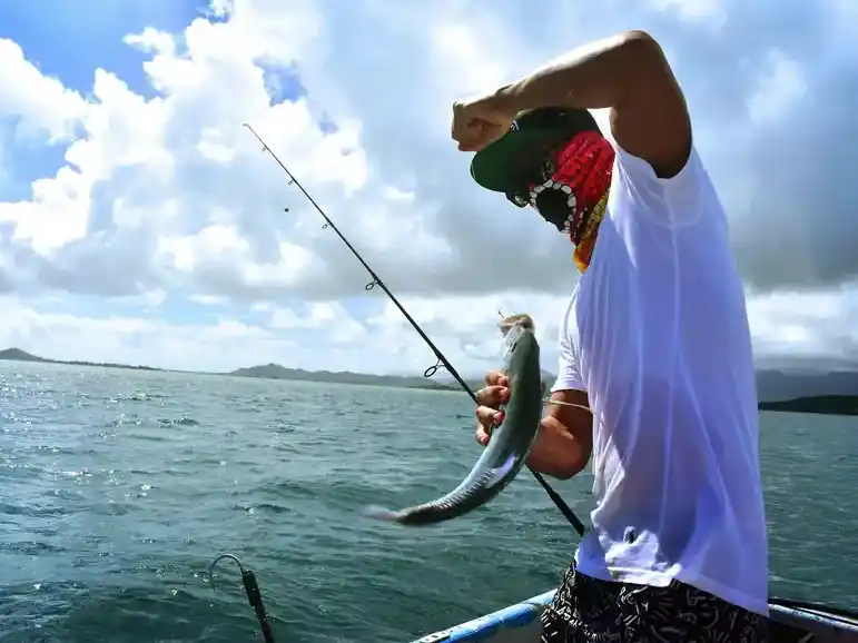 Guest showing off a fresh catch during a guided sea fishing excursion at Danglai Resort, Semporna