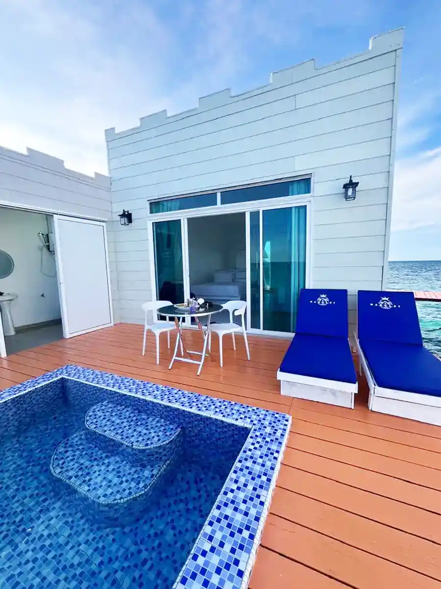 Exterior view of a premium water chalet at Danglai Resort Semporna featuring a private balcony, plunge pool, blue sun loungers, and ocean access.